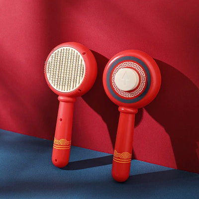 Deux brosses anti-mue MueZen rouges, l'une montrant ses picots, l'autre son bouton d'éjection, sur fond rouge et bleu