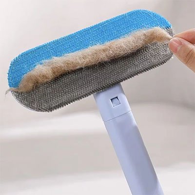 Brosse anti poil utilisée sur un vêtement pour enlever les poils de chat