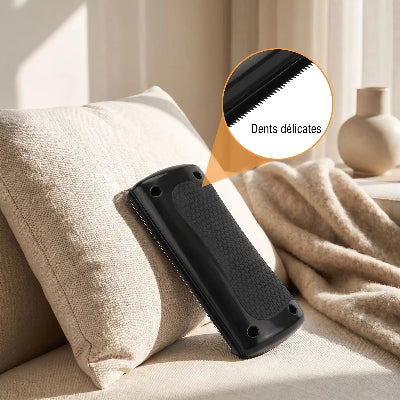 Brosse noire pour chat posée sur un canapé beige, avec un détail de sa surface texturée