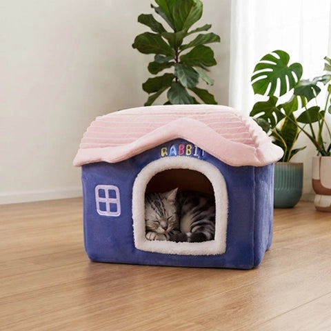 Chat tigré dans sa maisonnette pour chat bleue marine avec toit rose, vue lifestyle