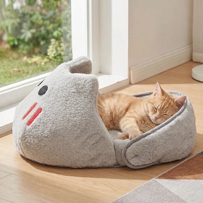 Chat roux endormi dans panier requin gris sherpa – mode semi-ouvert près d'une fenêtre
